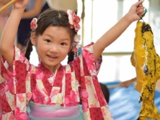夏まつりで魚つりを楽しむ浴衣姿の子ども