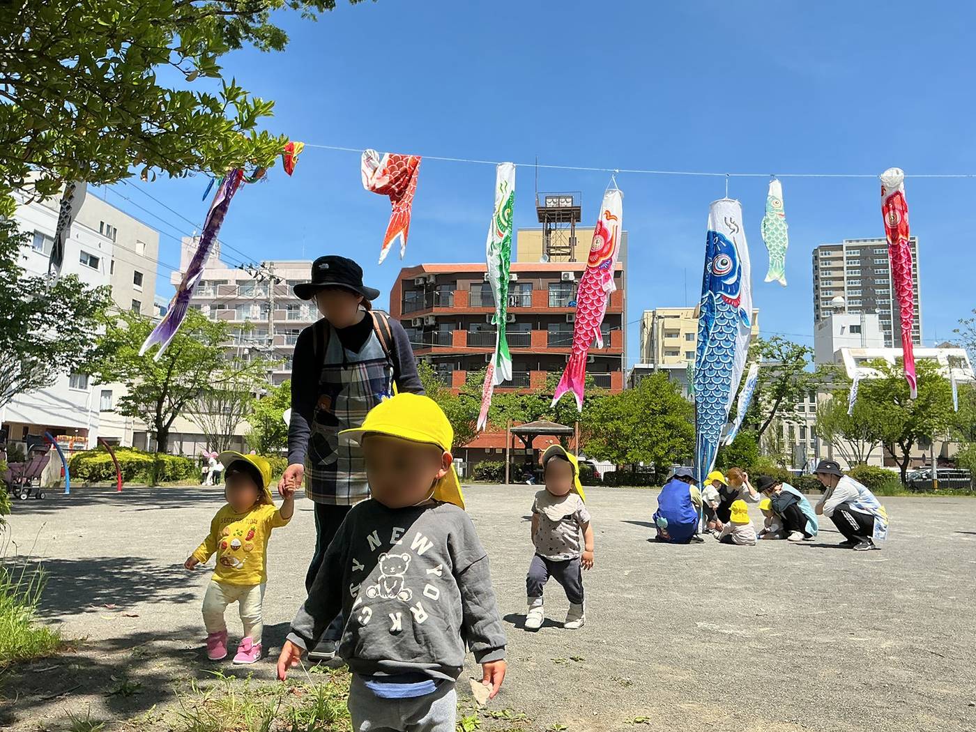 こいのぼりが泳ぐ公園にお散歩に出かけた子どもたち